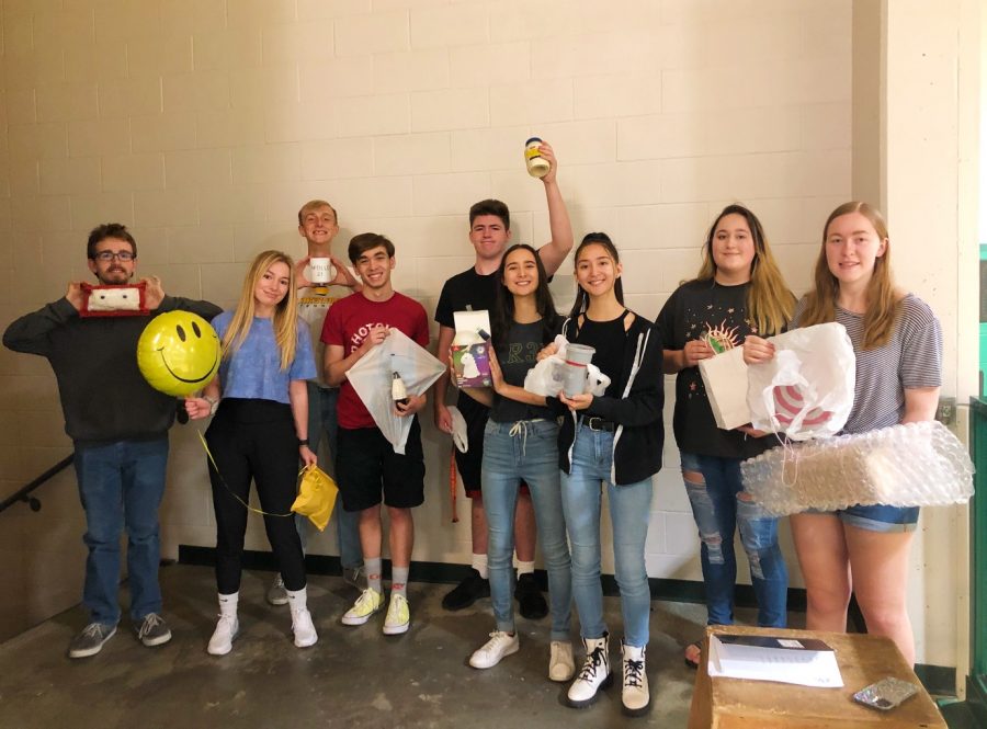 Mrs. Wenstrom’s Physics class holding up their second egg drop projects before they drop them.