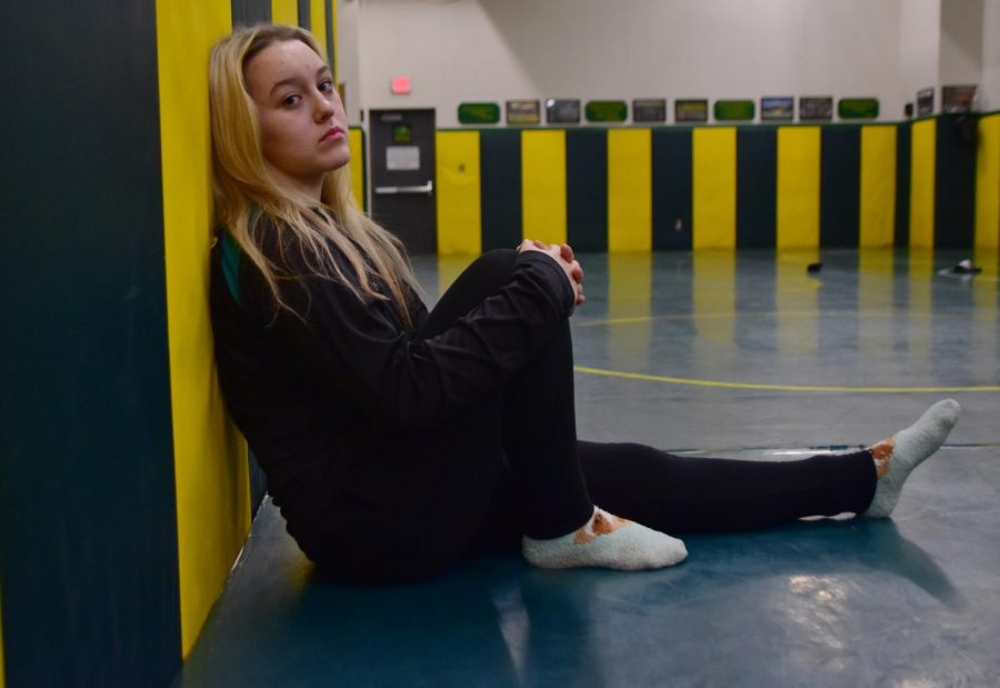 Female wrestler Annika Thompson sits in the Lakeland High School mat room
