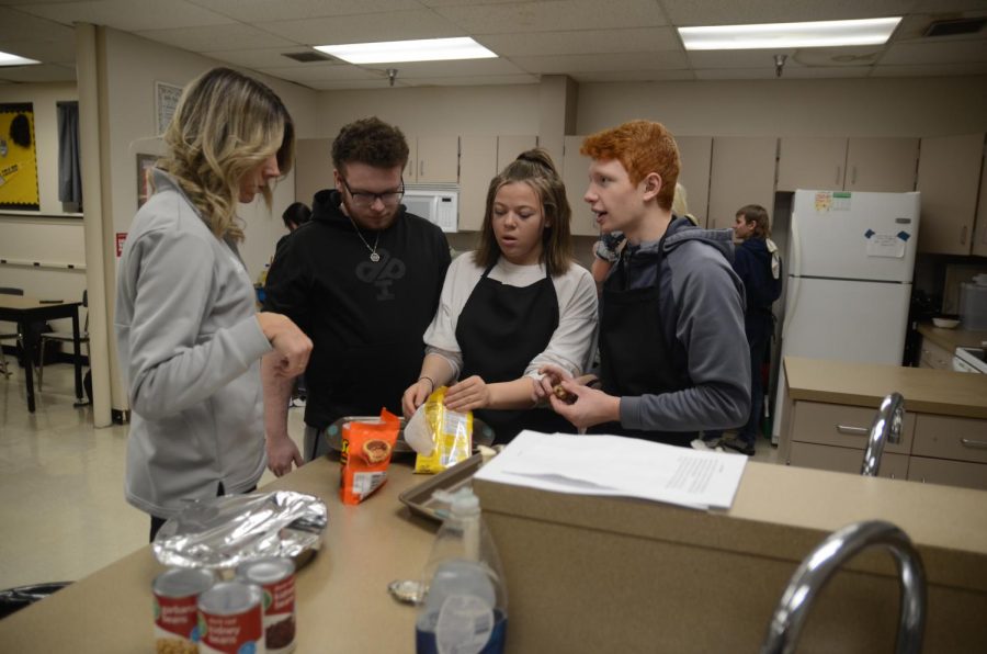 Sarah Nave helping students Brian Scholwinski, Johnnay Williams and Jayden Terry with their projects bake sale