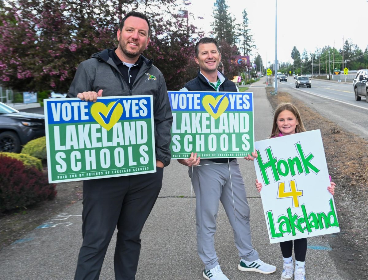 Principal Hoffman, Mr. Neff, and Kendall Neff smile with their signs. 